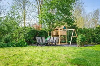 a backyard with a gazebo and a playground at Newly renovated luxurious Villa / hottub / sauna / 7 bedrooms in Zeewolde