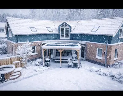 a house with snow on the roof of it at Newly renovated luxurious Villa / hottub / sauna / 7 bedrooms in Zeewolde