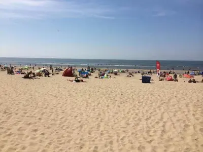 a group of people sitting on a beach at Holiday Home in Alkmaar by Canal in Alkmaar