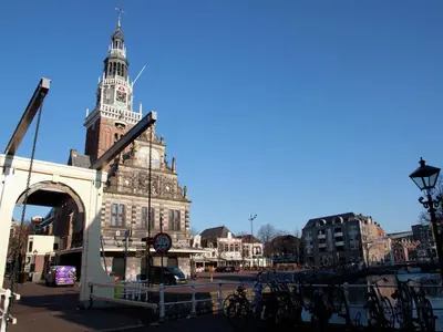 a large building with a clock tower in a city at Holiday Home in Alkmaar by Canal in Alkmaar