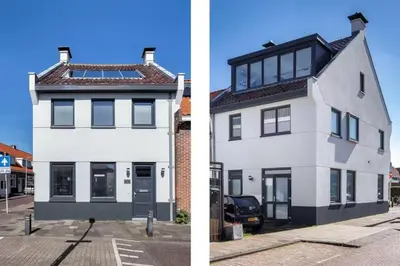 a white house with black windows and a parking lot at Hello Noordwijk - Wellness Huis Schoolstraat 47B in Noordwijk aan Zee