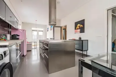 a large kitchen with stainless steel appliances and pink at Hello Noordwijk - Wellness Huis Schoolstraat 47B in Noordwijk aan Zee