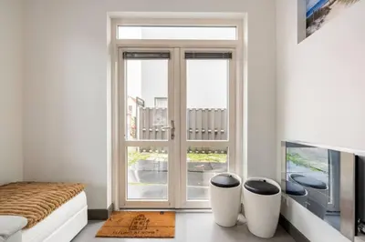 a bedroom with a bed and a large window at Hello Noordwijk - Wellness Huis Schoolstraat 47B in Noordwijk aan Zee