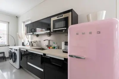 a kitchen with a pink refrigerator in a room at Hello Noordwijk - Wellness Huis Schoolstraat 47B in Noordwijk aan Zee
