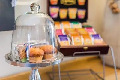 a glass cloche with donuts and muffins in it at Hotel Montfoort in Montfoort