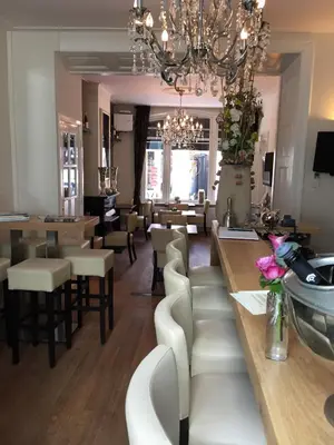 a salon with white chairs and a chandelier at Hotel Montfoort in Montfoort