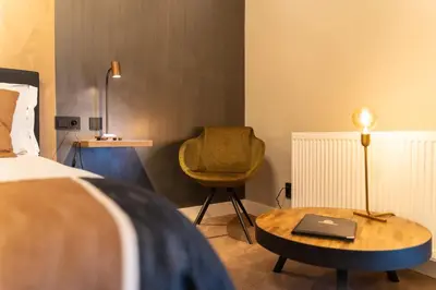 a bedroom with a bed and a table and a chair at Hotel Montfoort in Montfoort
