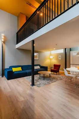 a living room with a blue couch and a table at Apartments De Hallen in Amsterdam