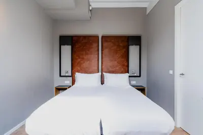 a bedroom with a white bed with two pillows at Apartments De Hallen in Amsterdam