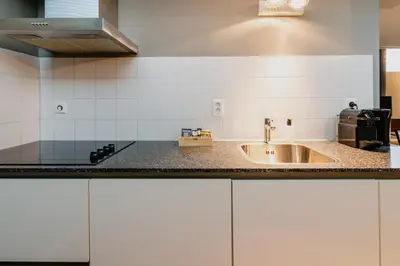 a kitchen with a sink and a counter top at Apartments De Hallen in Amsterdam