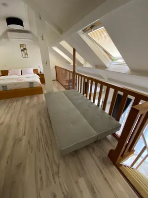 a bedroom with a bed and a staircase with windows at Appartement Lijnden in Lijnden