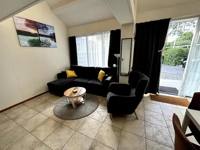 a living room with a couch and chairs and a table at Appartement Lijnden in Lijnden