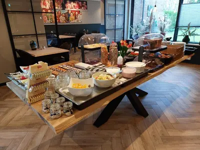 a long table with food on it in a restaurant at Hotel De Dennen in Egmond aan Zee