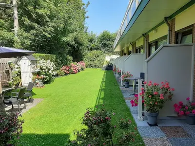 a garden with flowers and plants next to a building at Hotel De Dennen in Egmond aan Zee