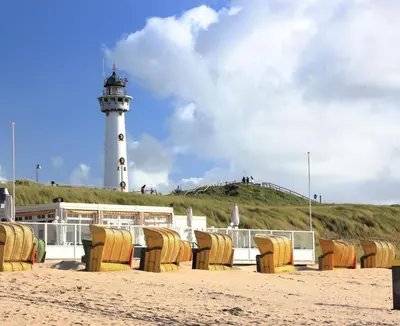 a lighthouse sitting on top of a sandy beach at Bundi Beach in Egmond aan Zee