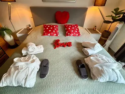 a bedroom with a bed with towels and love written on it at B&B Wellness Soest in Soest
