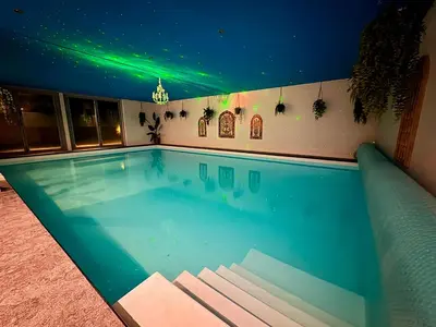 a swimming pool at night with green lights at B&B Wellness Soest in Soest