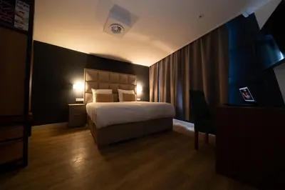 a hotel room with a bed and a desk and chair at MA Airport Hotel in Hoofddorp