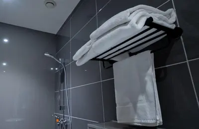 a towel hanging on a rack in a bathroom at MA Airport Hotel in Hoofddorp