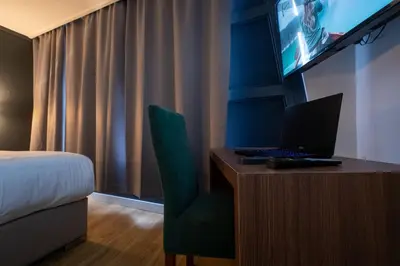 a hotel room with a desk with a laptop on it at MA Airport Hotel in Hoofddorp