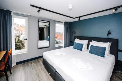 a bedroom with a large bed with a blue wall at Amsterdam Beach Hotel in Zandvoort