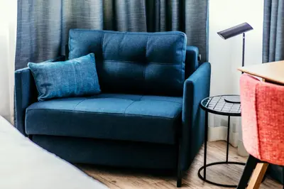 a blue chair with a blue pillow in a room at Amsterdam Beach Hotel in Zandvoort
