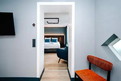 a bedroom with a bed and a chair in a room at Amsterdam Beach Hotel in Zandvoort