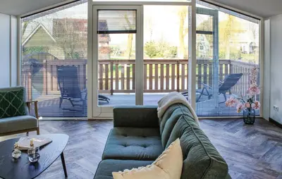 a living room with a couch and large windows at Braassermerhuis in Rijnsaterwoude