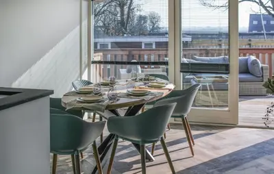 a dining room with a table and chairs and a large window at Braassermerhuis in Rijnsaterwoude