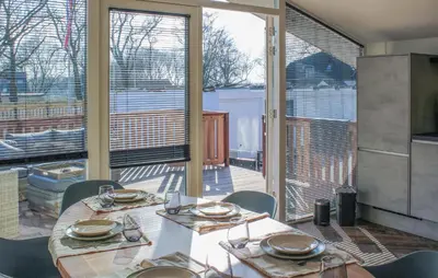 a dining room with two tables and a large window at Braassermerhuis in Rijnsaterwoude