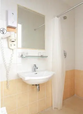 a bathroom with a sink and a mirror at Ambassador City Centre Hotel in Haarlem