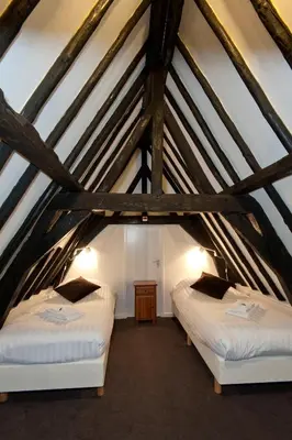 two beds in the attic of a building at Ambassador City Centre Hotel in Haarlem