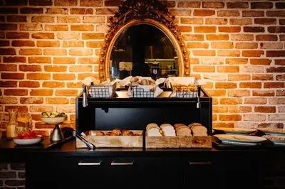 a shelf filled with lots of bread and a mirror at Ambassador City Centre Hotel in Haarlem