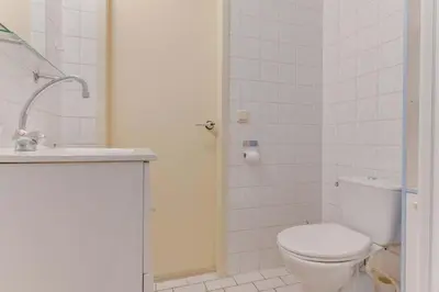 a white bathroom with a toilet and a sink at Rekerlanden 274 in Warmenhuizen