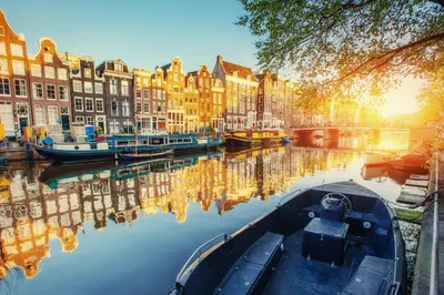 a boat is docked in a canal with buildings at Luxury House With 2 Private Independent Studios 120 m2 Near LEIDSEPLEIN CITY CENTRE AMSTERDAM - Paid Parking Possibilities Nearby in Amsterdam