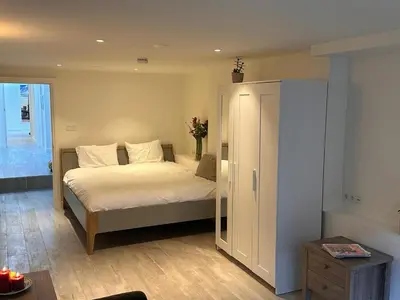 a bedroom with a bed with white sheets and a cabinet at Luxury House With 2 Private Independent Studios 120 m2 Near LEIDSEPLEIN CITY CENTRE AMSTERDAM - Paid Parking Possibilities Nearby in Amsterdam