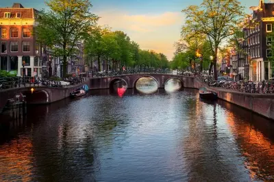 a river in a city with a bridge and buildings at Luxury House With 2 Private Independent Studios 120 m2 Near LEIDSEPLEIN CITY CENTRE AMSTERDAM - Paid Parking Possibilities Nearby in Amsterdam