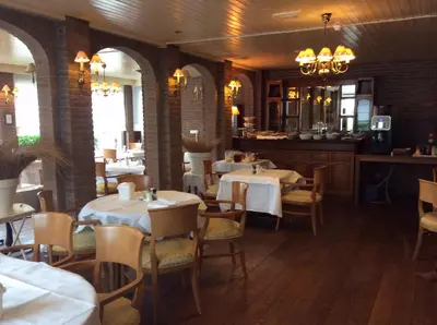 a dining room with tables and chairs and a bar at Hotel de Admiraal in Noordwijk aan Zee