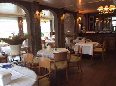 a restaurant with tables and chairs in a room at Hotel de Admiraal in Noordwijk aan Zee