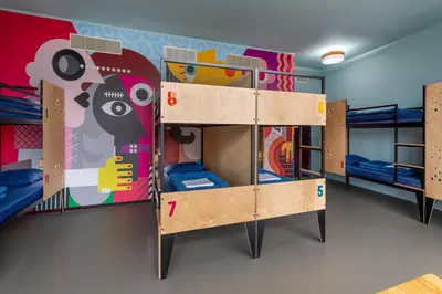 a room with three bunk beds and a mural at Stayokay Hostel Amsterdam Stadsdoelen in Amsterdam