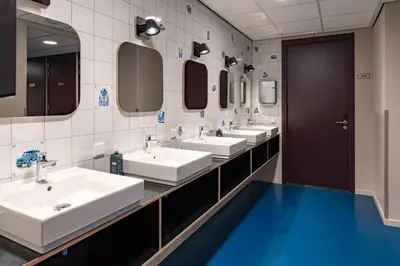 a bathroom with four sinks and a row of mirrors at Stayokay Hostel Amsterdam Stadsdoelen in Amsterdam