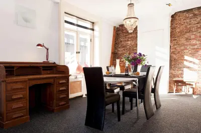 a dining room with a desk and a table with chairs at Canal Holiday Apartment in Amsterdam