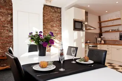a dining room table with a black table cloth and flowers at Canal Holiday Apartment in Amsterdam