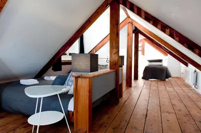 a bedroom with a bed and a desk in a attic at Canal Holiday Apartment in Amsterdam