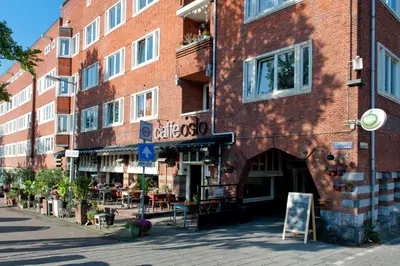 a red brick building with a restaurant on a street at Canal Holiday Apartment in Amsterdam