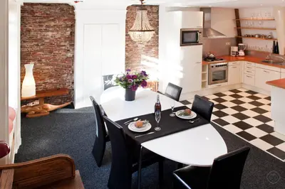 a kitchen and dining room with a white table and chairs at Canal Holiday Apartment in Amsterdam
