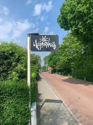 a street sign with graffiti on the side of a road at ´t Kappershuis in Groet