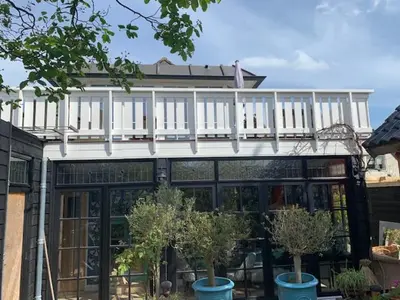 a building with a balcony on top of it at ´t Kappershuis in Groet