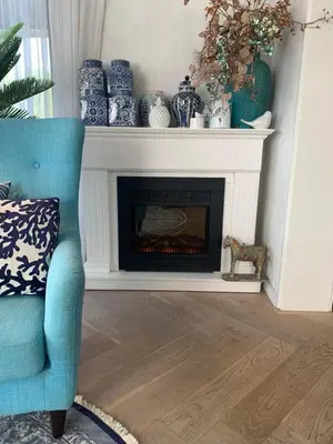 a living room with a fireplace with blue and white vases at ´t Kappershuis in Groet