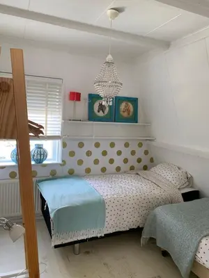 a bedroom with a bed with a polka dot bedspread at ´t Kappershuis in Groet